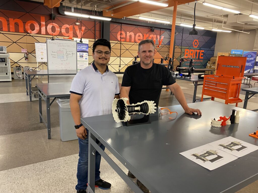 Lab Director Mike Drenski and Lab intern Sahaj standing in front of a 3D printed prototype at BRITE Energy Labs