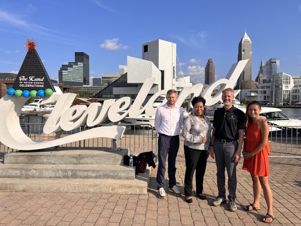 Jing Lyon, India Birdsong Terry, and BRITE member companies standing near Cleveland sign